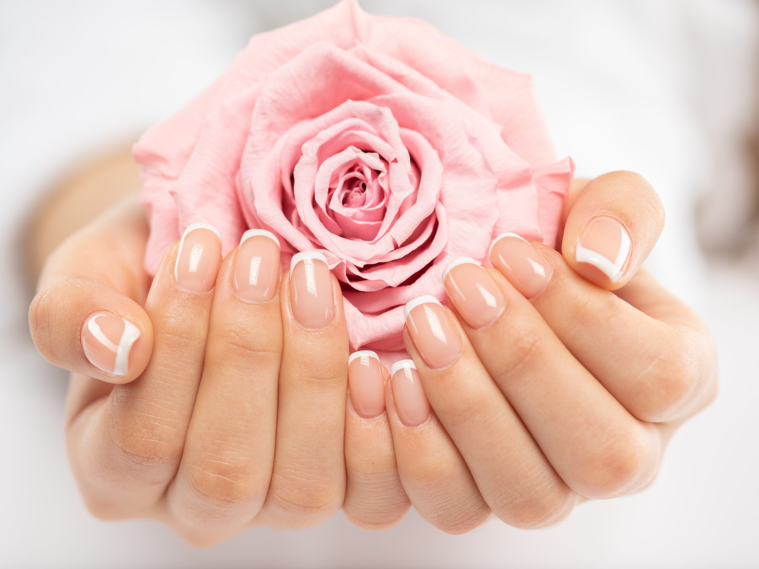 Woman gets manicure procedure in a spa salon. Beautiful female hands. Hand care. Woman cares for the nails on hands. Beauty treatment with skin of hand.   Woman's hands close-up view.
